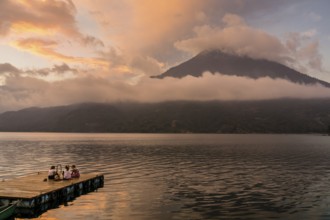 Tourists on a mooring enjoying the sunset, Lake Atitlan and San Pedro volcano, Santiago Atitlan,