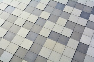 Detail of the façade of a modern building in Magdeburg. The façade is clad with square stone slabs
