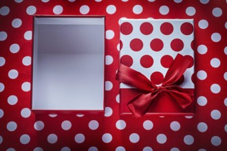 Opened present box on polka-dot red fabric celebrations concept