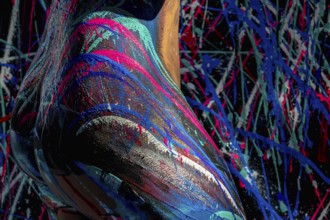 A model poses gracefully, her body adorned in vibrant body paint, with brilliant, sweeping strokes