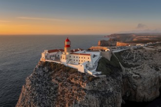 Portuguese coast with a lighthouse in the rays of the setting sun, Cabo De Sao Vincente on sunset