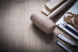 Wooden bricks mallet curled up scobs chisels try square pencil on wood board construction concept