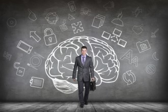 Woman stands beside big drawn brain on the gray wall