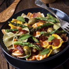 Pasta salad with green asparagus, olives and Parma ham