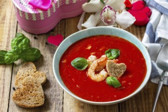 Homemade Valentine soup, festive food. Tomato soup puree gazpacho with tomatoes served seafood on a