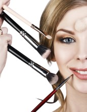 Many hands with cosmetics brushes applying make-up to glamour woman, over white background
