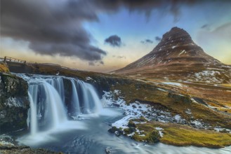 Famous waterfall under the conical mountain Kirkjufellsfoss
