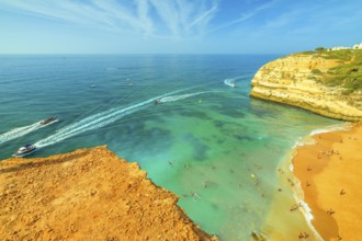 Aerial view of golden cliffs of Praia de Benagil in Algarve near Lagoa, Portugal, Europe. Boat