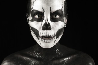 Isolated on black, closeup picture, beautiful young blonde caucasian woman with scull body art,