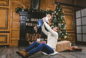 Happy father and son at home near Christmas tree. New Year and Christmas theme. Holiday mood.