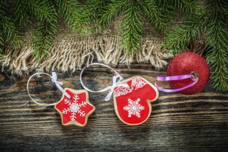 Pine tree branches bagging Christmas ball gingerbread on wood board
