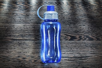 Plastic water shaker on vintage wooden board