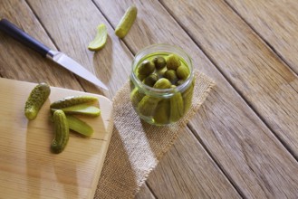 Bottled pickles cucumbers in vintage wooden table