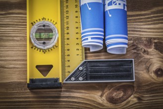 Blue engineering drawings construction level square ruler on wooden board