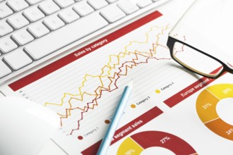 Business workplace with keyboard mouse and papers with graphs and diagrams