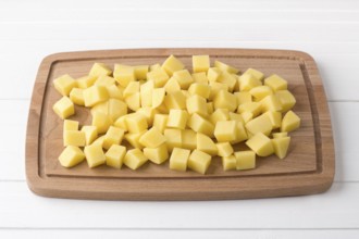 Food, Wooden board with fresh diced potatoes on a light gray background. Stage of cooking vegetable