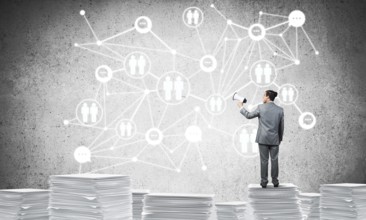 Businessman with speaker in hand standing on pile of documents with social network structure on