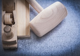 Planer lump hammer wooden brick on metallic background construction concept