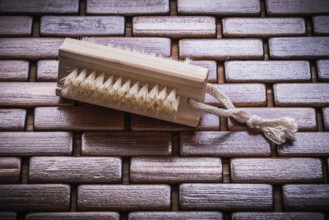 Wood scrubbing brush on textured wooden matting top view healthcare concept