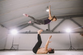 Young couple Couple practicing acro yoga in gym. Healthy lifestyle. Acroyoga. Couple yoga. Partner
