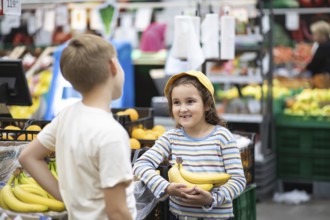 Kids little cute girl and teenager boy shopping for fresh organic fruits bananas and vegetables in