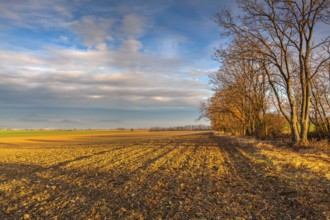 Autumn morning landscape over the city of Louny. Autumn plowed field at amazing sunrise. Czech