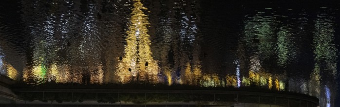 Reflection of a decorated Christmas tree in the water at Corneliusplatz on Königsallee in