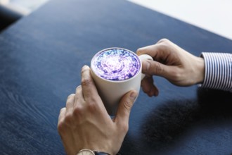 Coffee cup with cosmos space on wooden table