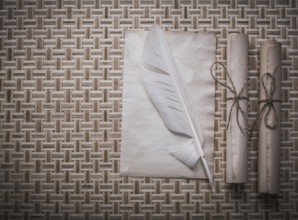 Rolls of vintage paper clean sheet quill on wicker mat