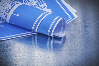 Blue blueprints on scratched metallic background construction concept