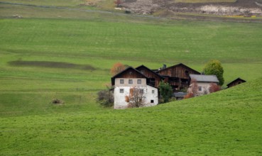 Traditional wooden cottage mountain houses in the green field in the dolomites. Housing in