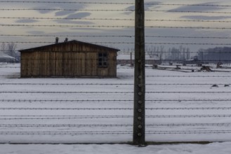 A view of the outside fence at the camp in Birkenau with winter snow on the ground. Birkenau,