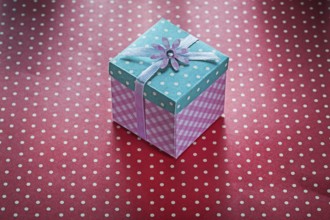 Present box on red polka-dot table cloth celebrations concept