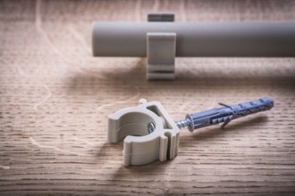 Close Up Pipe With Clips And Polypropylene Fixator On Wooden Board