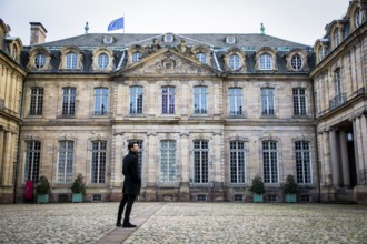 Attractive young man standing in courtyard of historic building in Strasbourg, France
