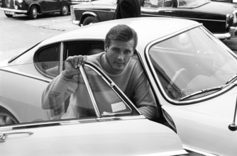 Sir Roger Moore, 1927-2017 during the filming of the tv-series The Saint, posing with a Volvo P1800
