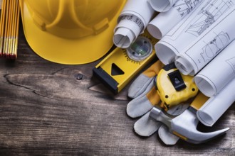 Blueprint rolls and set of construction tools on vintage pine wooden board maintenance concept