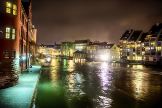 Scenic view View on river in Strasbourg, France at night. Romantic lights reflecting on the water