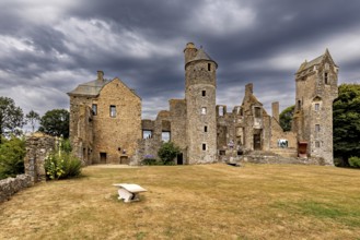Historic castle with towers and dramatic sky on a lawn, Gratot Castle in Normandy, France