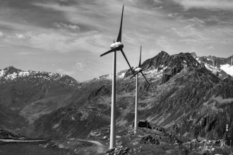 Wind Turbine and Mountain with Glacier and Against Sky and Clouds in a Sunny Summer Day in