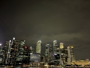 Illuminated skyline of a city at night with high skyscrapers and a dark sky, singapore, aisia