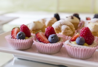 Close up of fresh and tasty cakes with fruits and berries