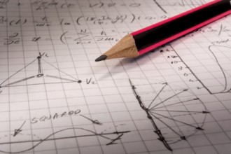 Pencil on notebook, full of mathematical formulas