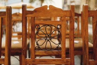 Forged pattern on the back of a wooden chair. Close-up.