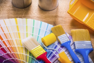 Very close up view paint brushes roller tray on wooden board