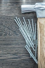Stainless construction nails claw hammer on wooden board
