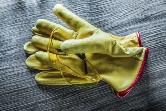 Set of safety gloves goggles on wooden board