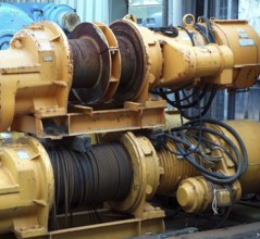 Large industrial winches are used to haul in steel cables