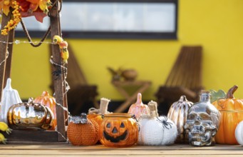 Autumn decor on the porch of the house outside in the yard of pumpkin, lantern, garlands, hats,