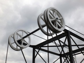 Wheels and pulleys on the historic canal chain bridge in Huddersfield West Yorkshire against grey